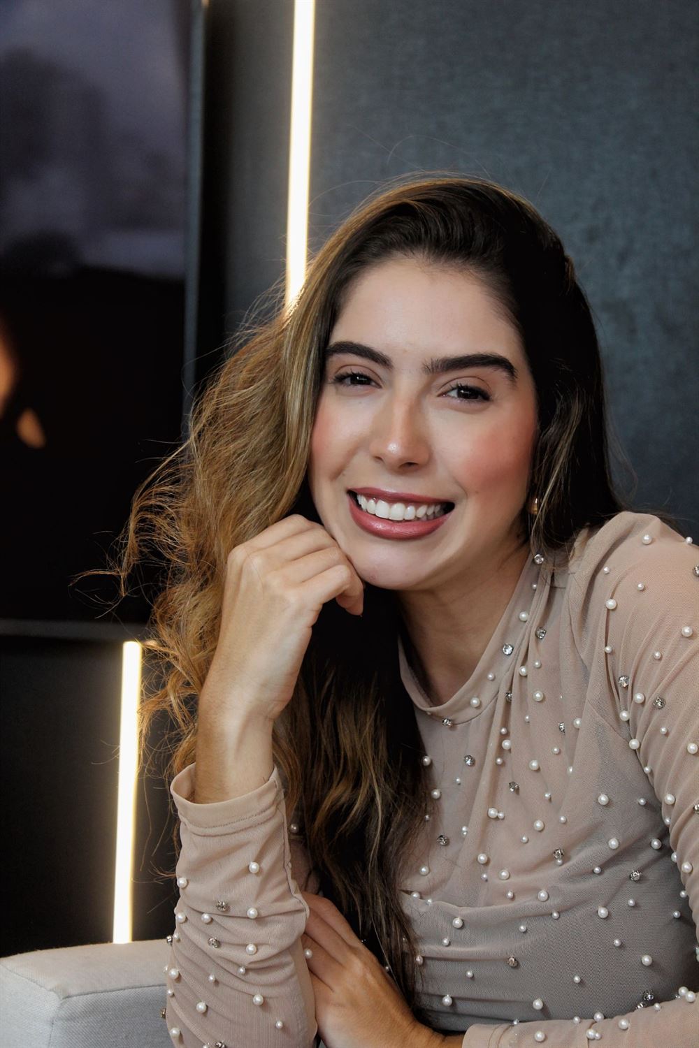 Dra. Débora Guedes sorrindo no consultório